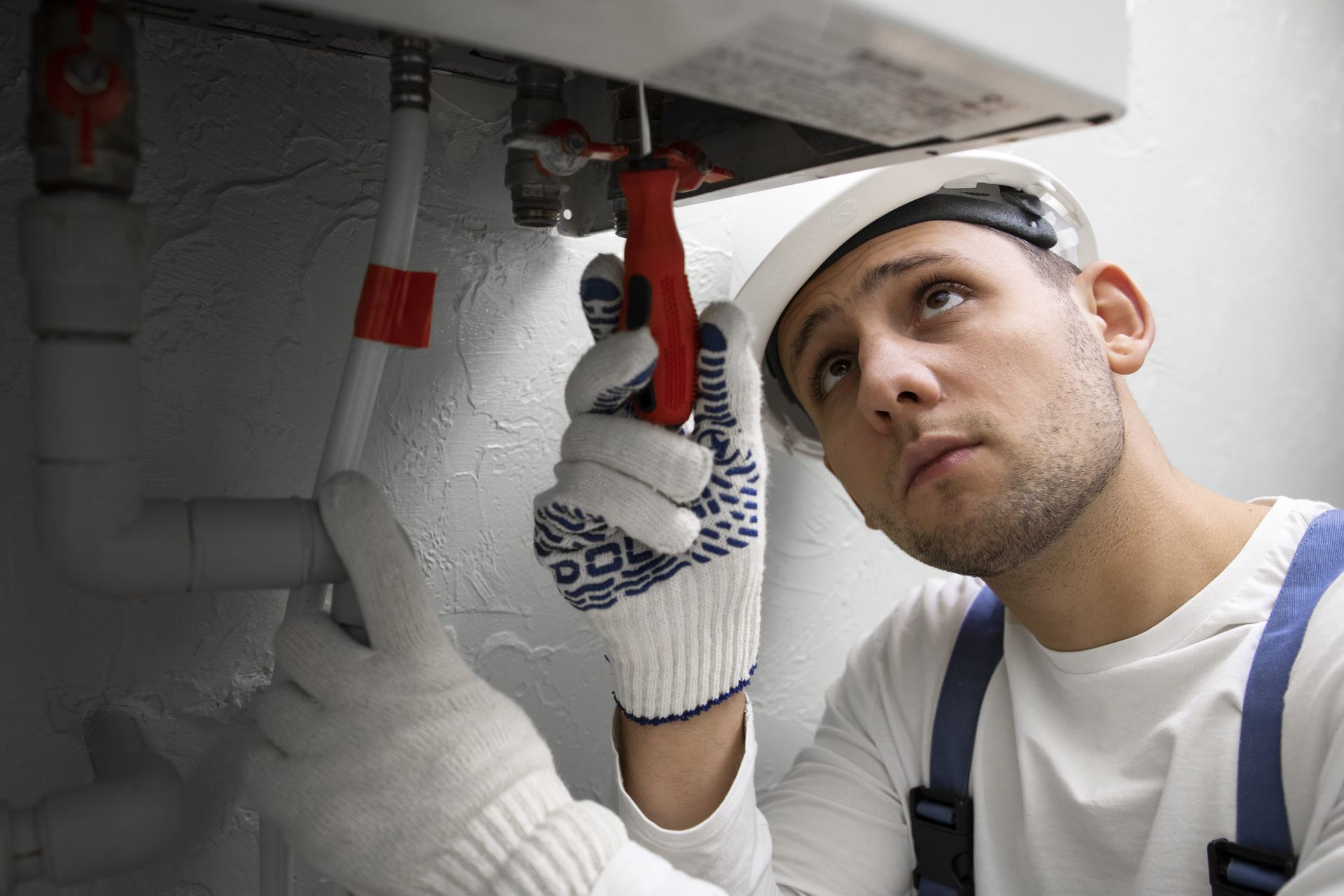 A man is painting the side of a building with a roller.