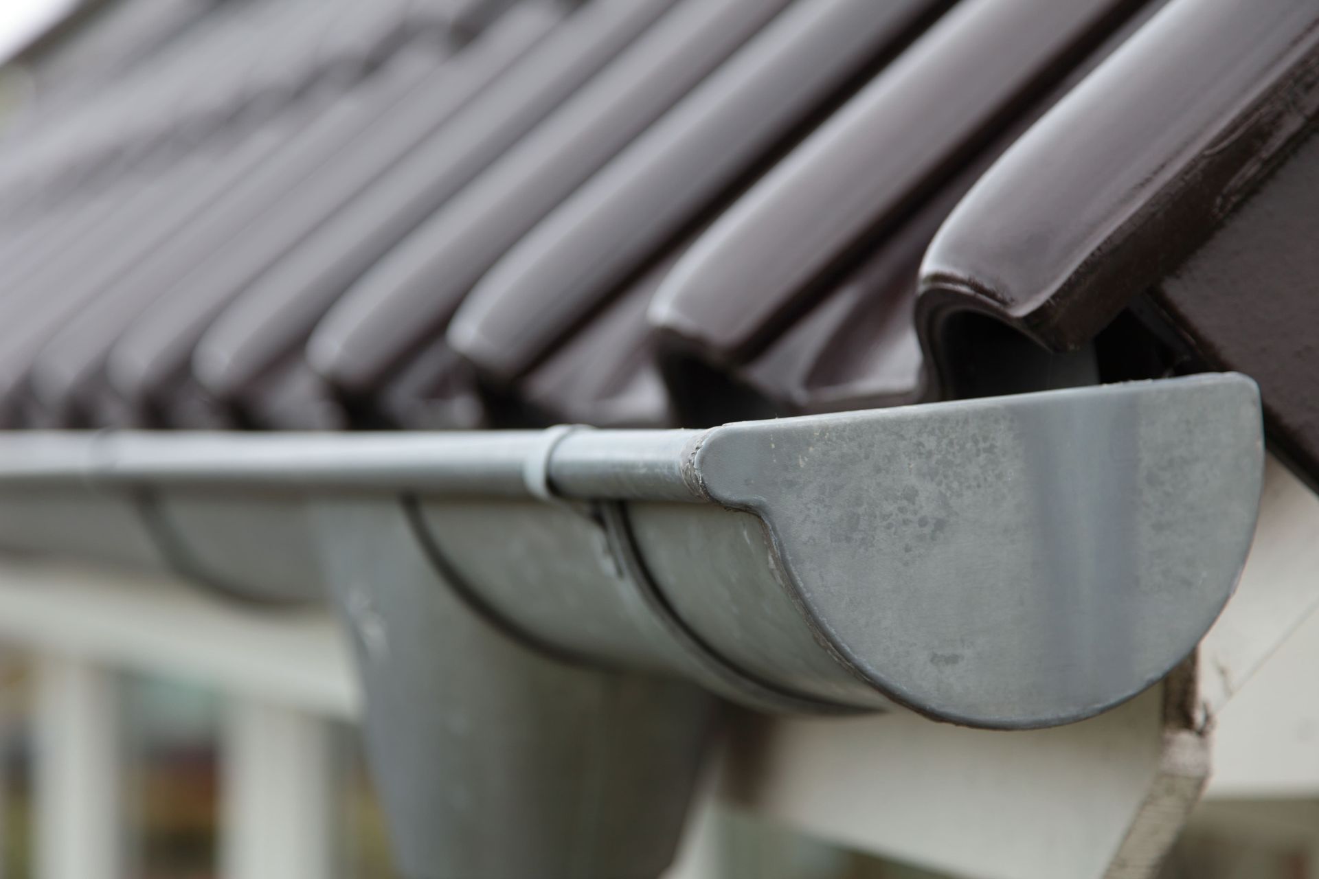 A close up of a gutter on the roof of a house.