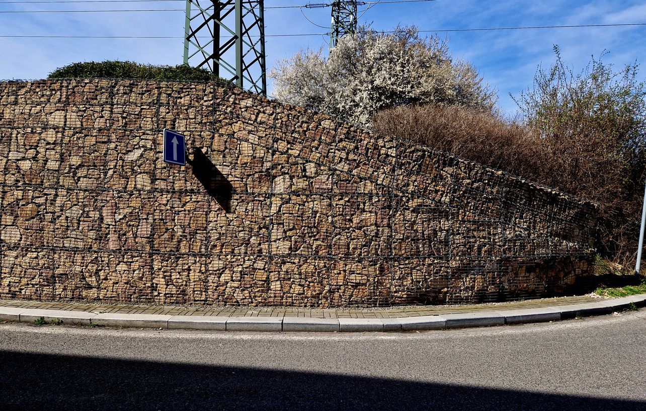 Un muro de piedra al costado de una carretera.