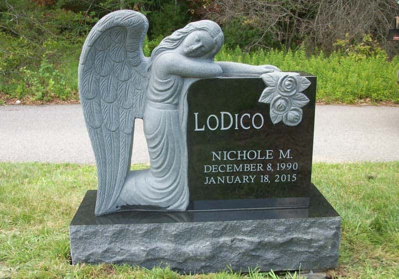 Black headstone with angel statue, engraved with 
