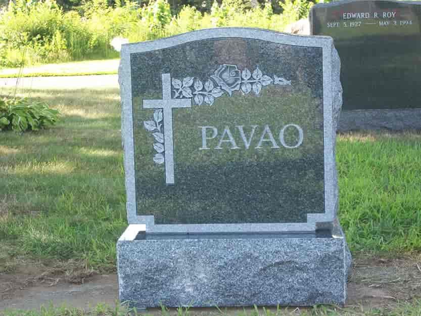 Gray granite gravestone with cross, rose, and the name PAVÃO in a cemetery.