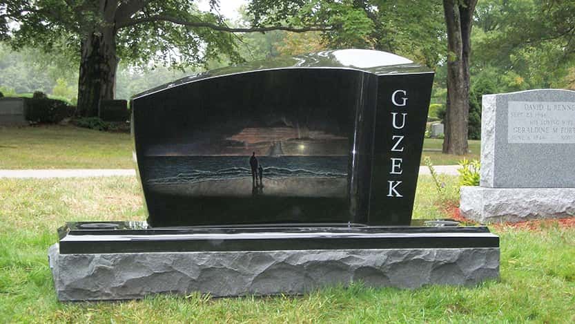 Black granite tombstone with etched water scene, 