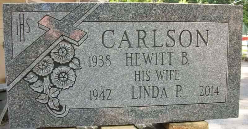Tombstone of Carlson family: Hewitt B. (1938-), his wife Linda P. (1942-2014), with cross and flower carvings.