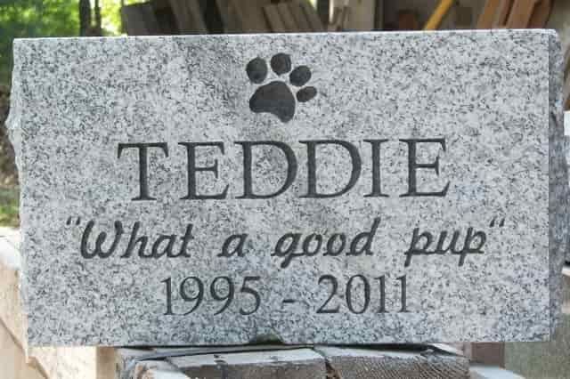 Grey granite pet memorial for Teddie, with a paw print, name, dates 1995-2011, and inscription 