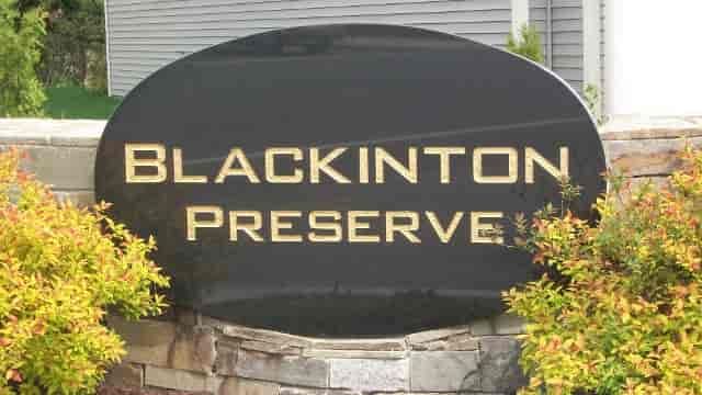 Black sign with gold lettering reads 