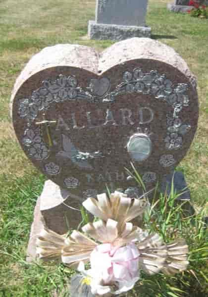 Heart-shaped Allard family gravestone with floral design and memorial flowers.