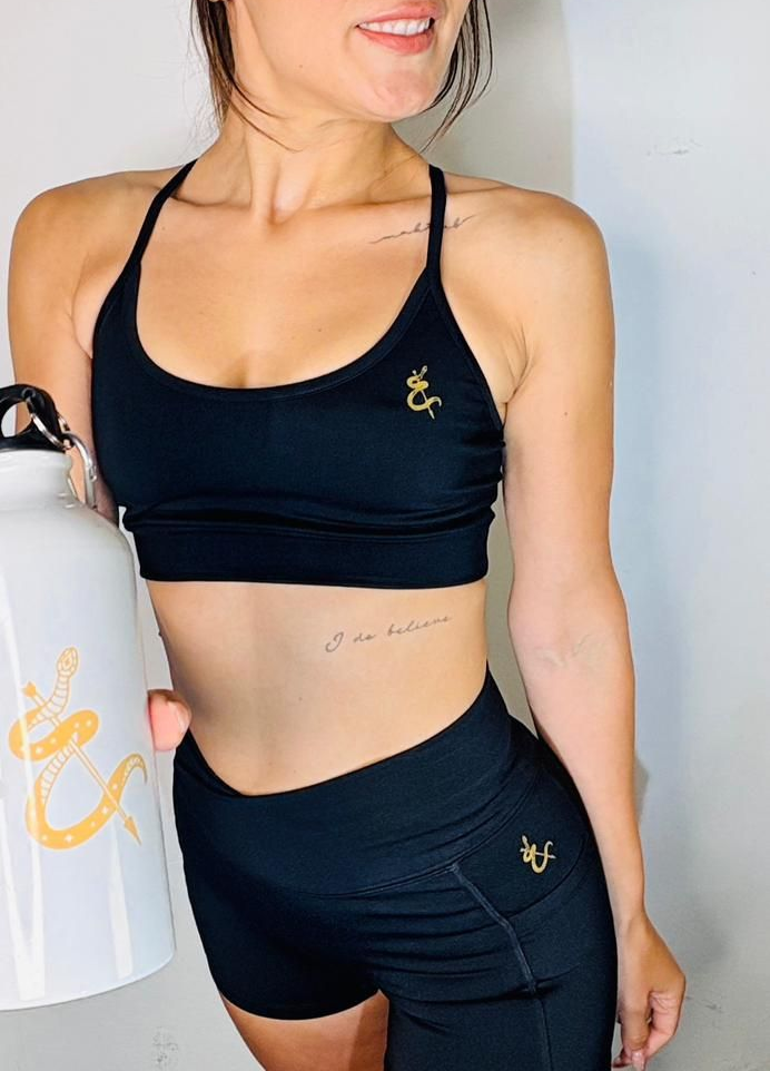 Botella de agua blanca con diseño de serpiente y daga dorada.