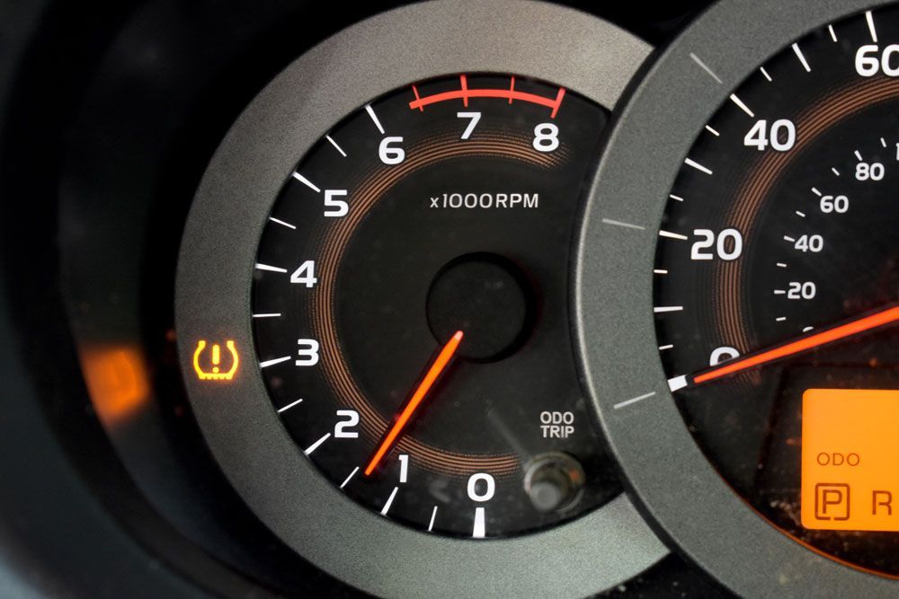 Car dashboard with the tire pressure warning light illuminated.