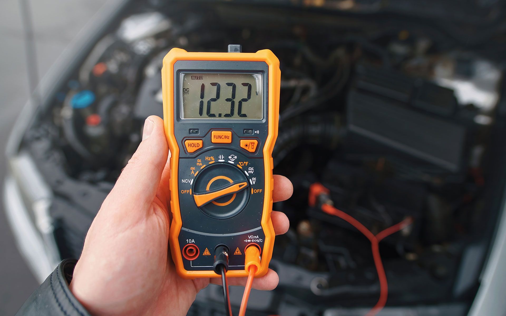 A bulldozer is plowing a field with mountains in the background.