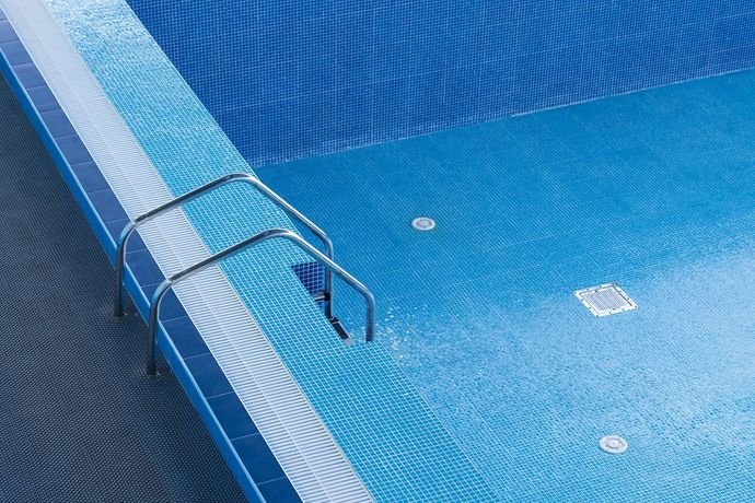 A close up of a swimming pool with stairs leading into it.