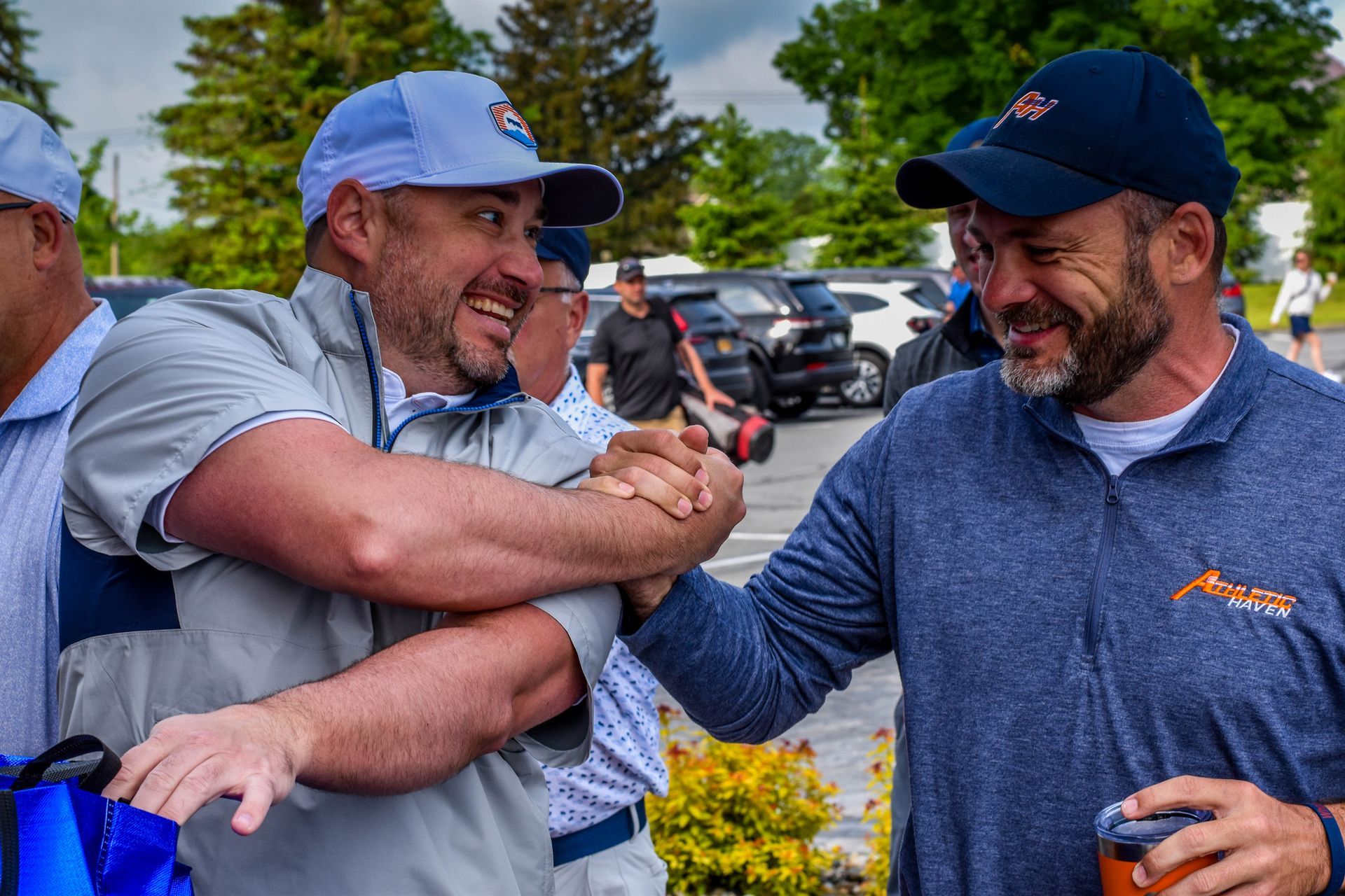 two men laughing and shaking hands
