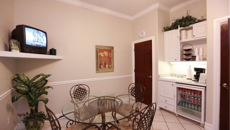 A kitchen with a table and chairs and a tv