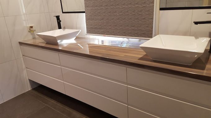 A bathroom with two sinks and a mirror.