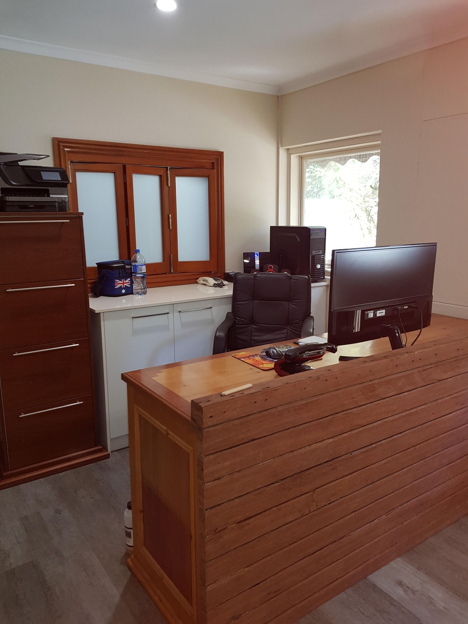 A wooden desk with a computer on it in a room.