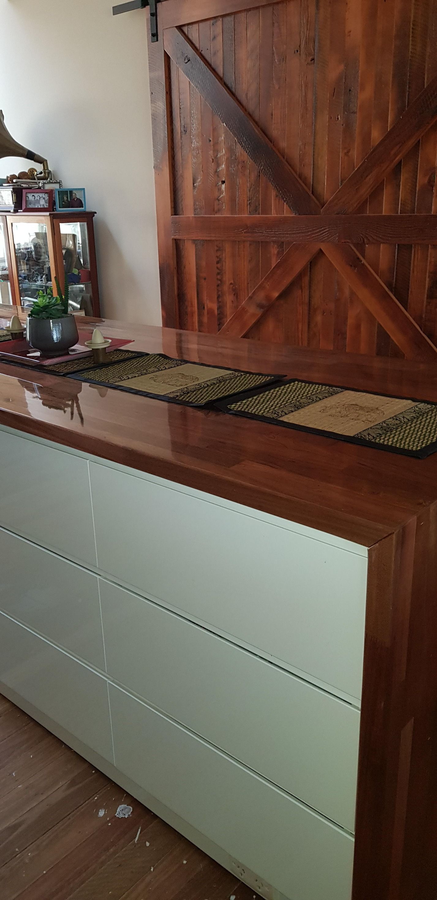 A wooden dresser with a sliding barn door in the background in a living room.
