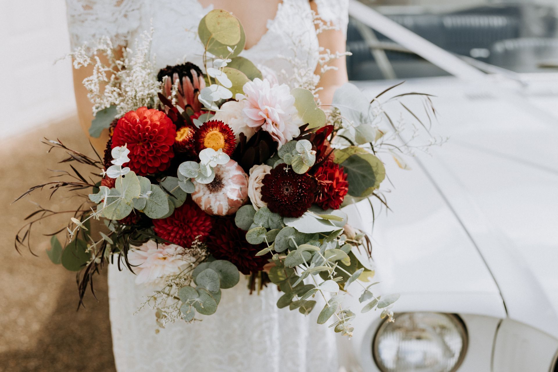 A couple outside in a park holding some wedding flowers— Flowers by Suzanne in Maitland, NSW