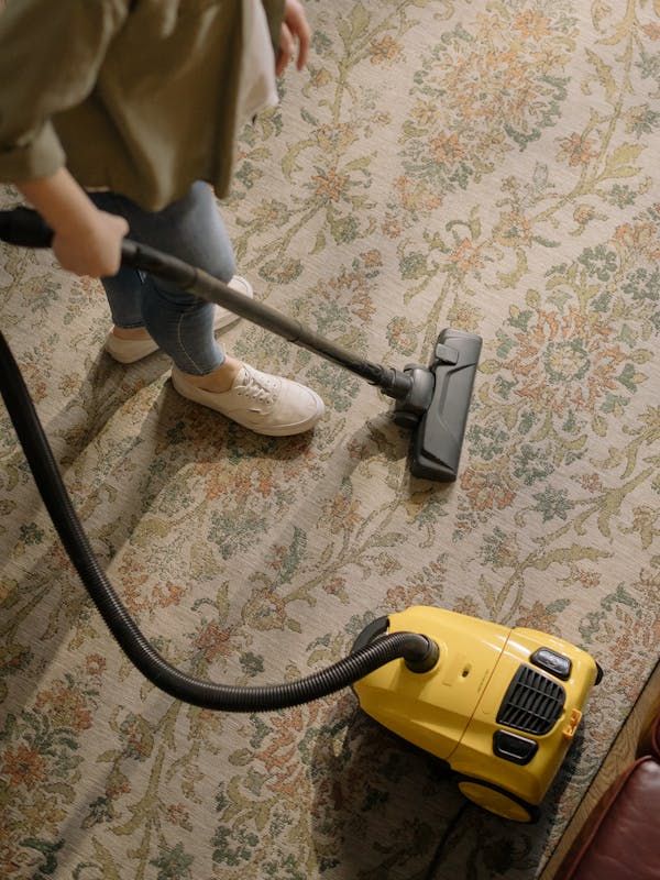 A person wearing yellow gloves is cleaning an office chair
