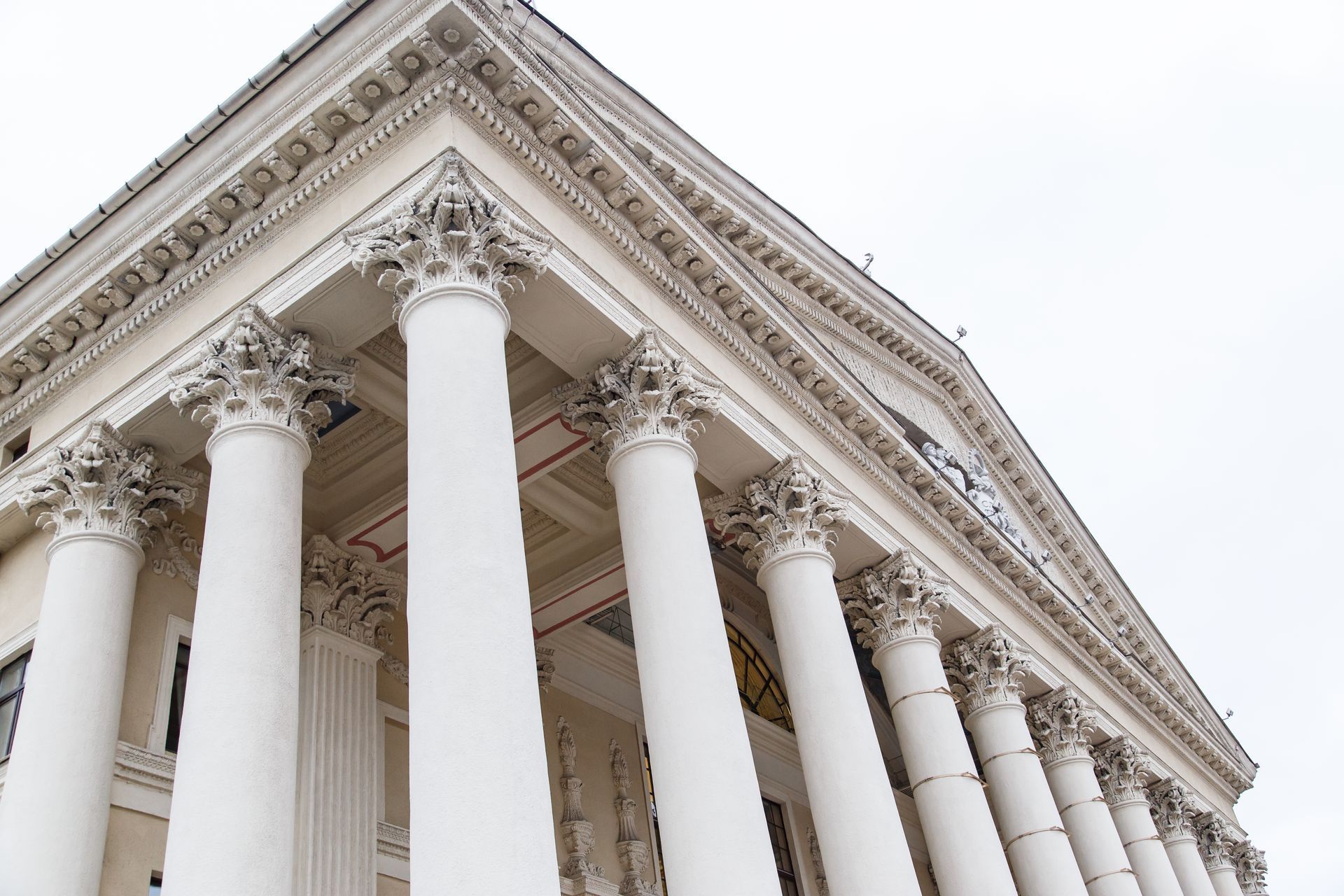 A large white building with columns and a white sky in the background