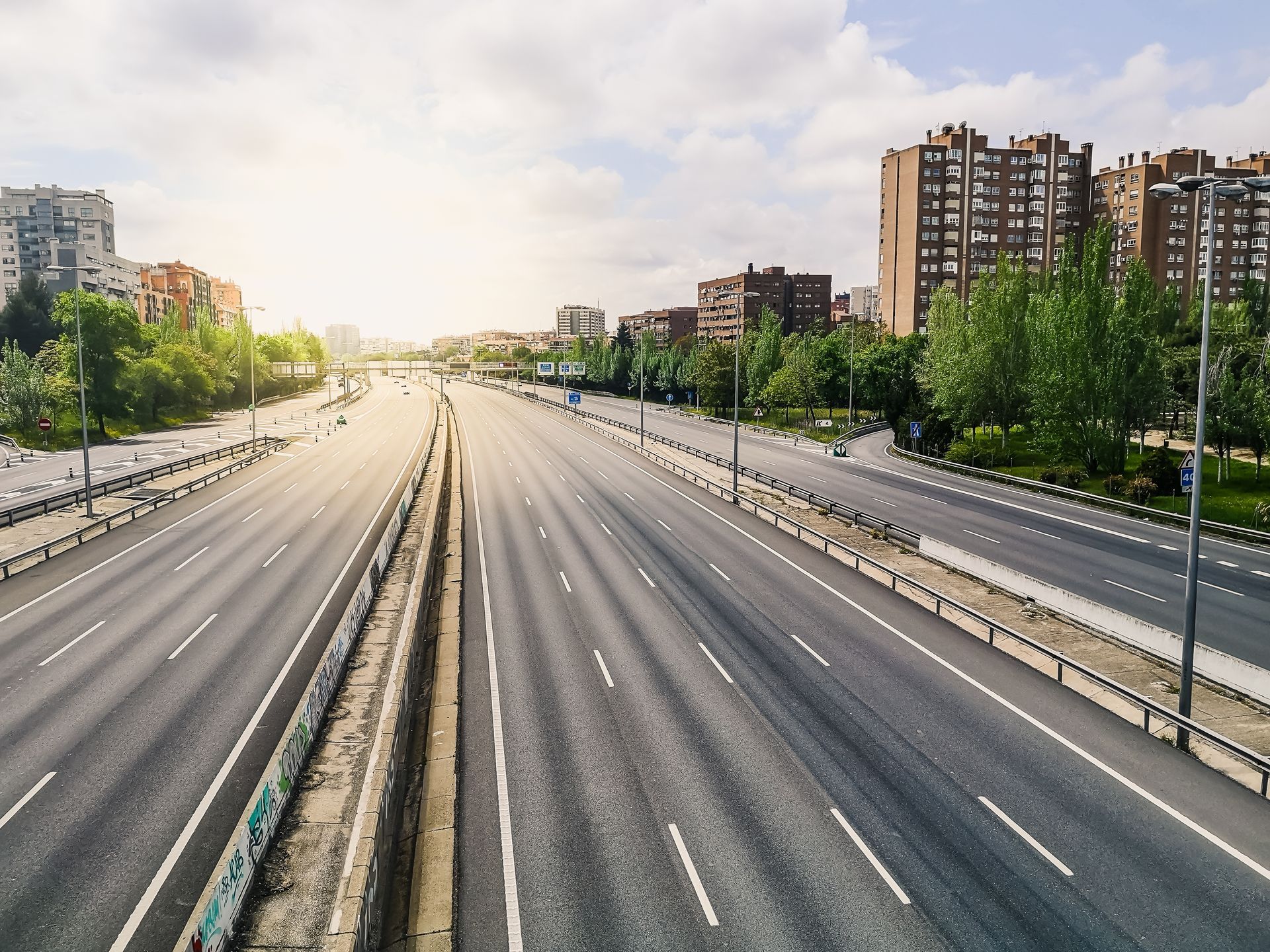 An aerial view of an empty highway with buildings in the background