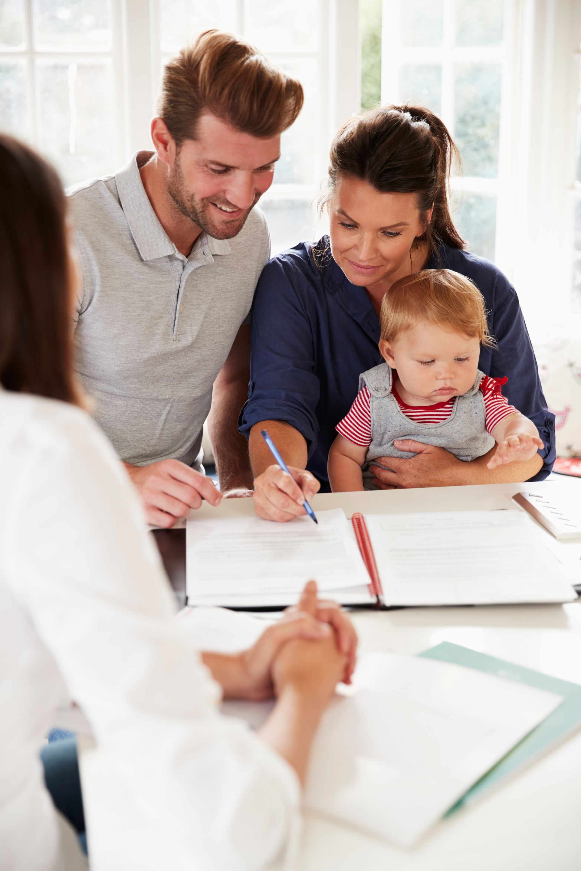 A family is sitting at a table with a baby.