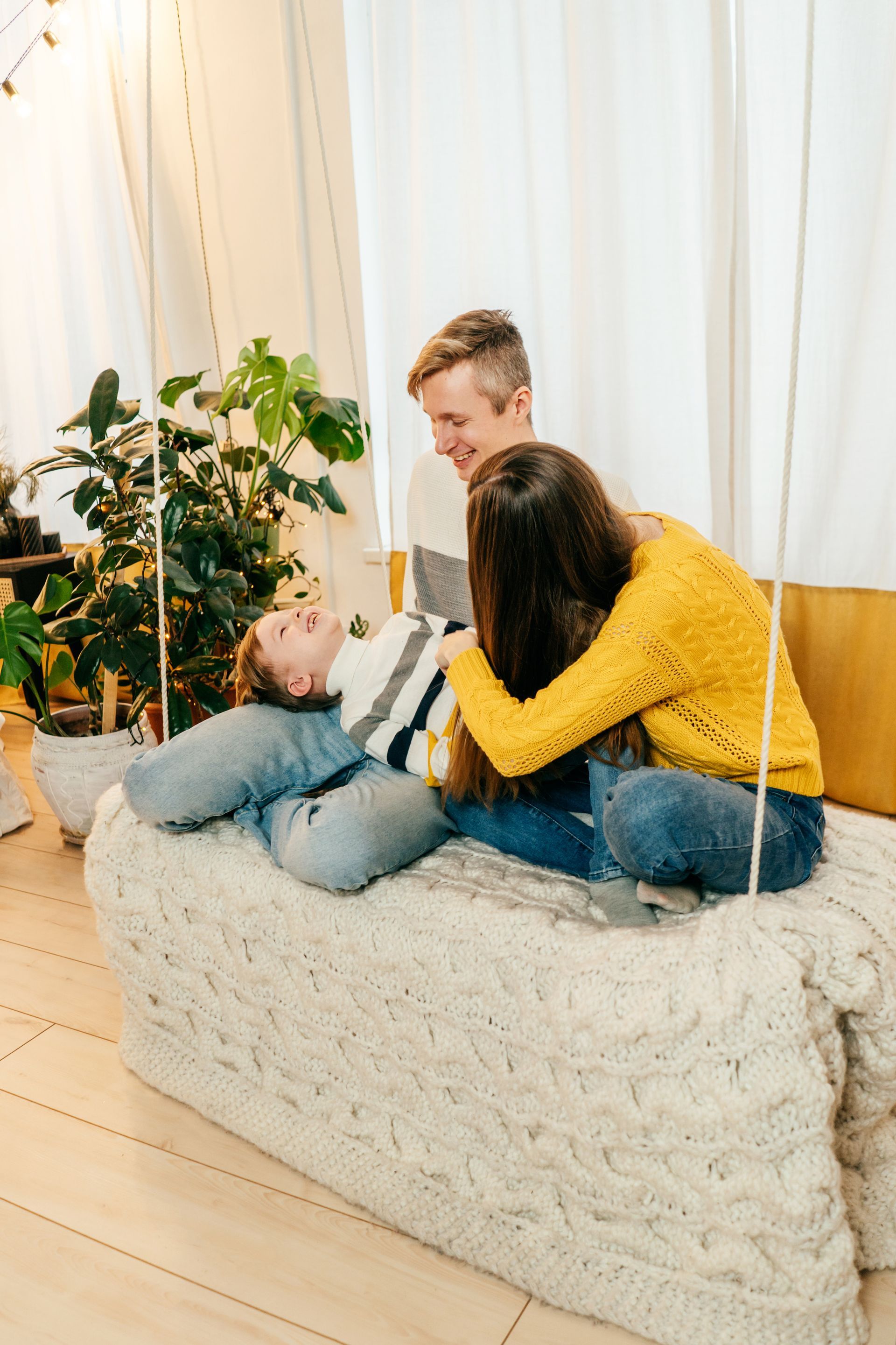 A family is sitting on a couch in a living room.