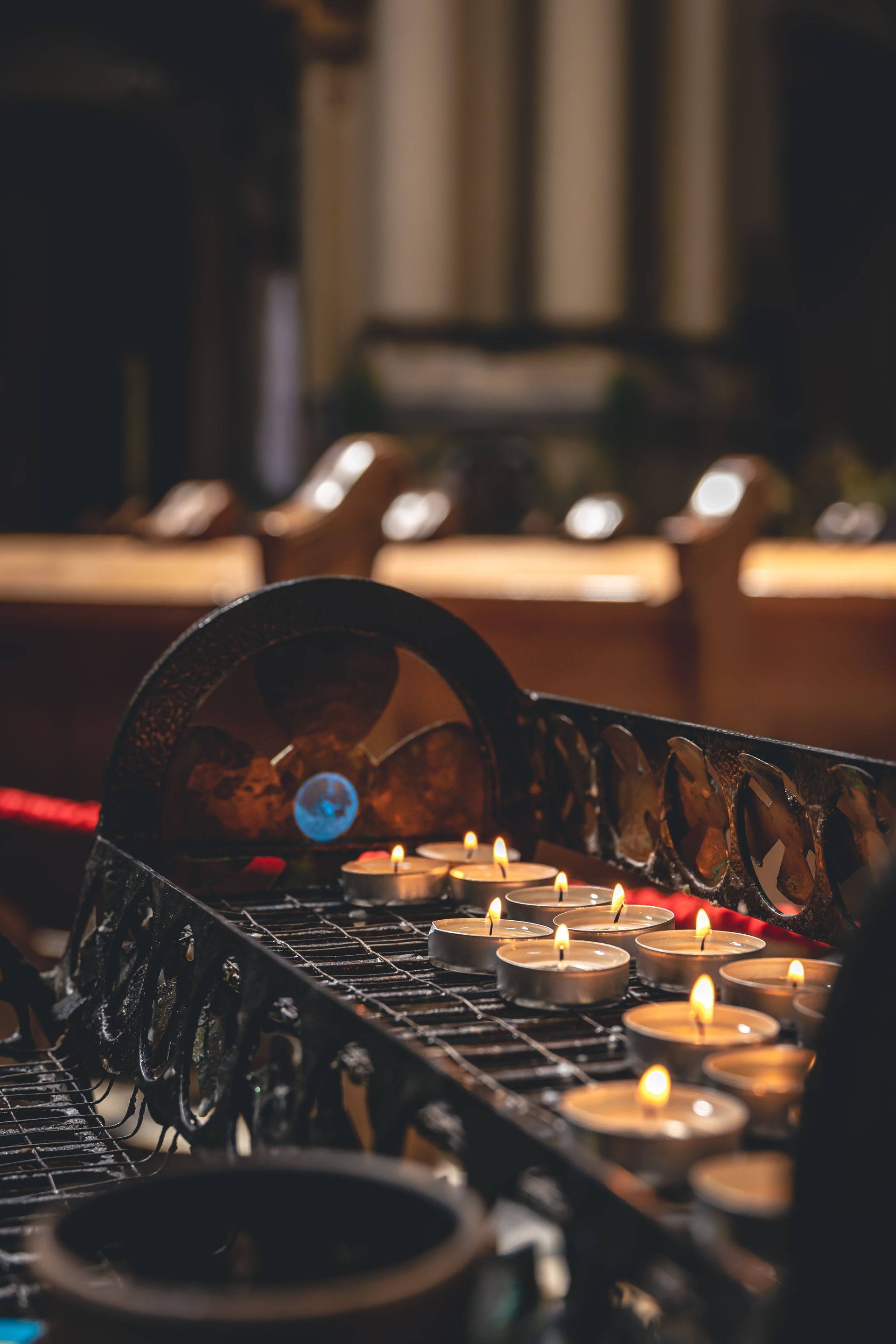 A row of candles are lit in a church.