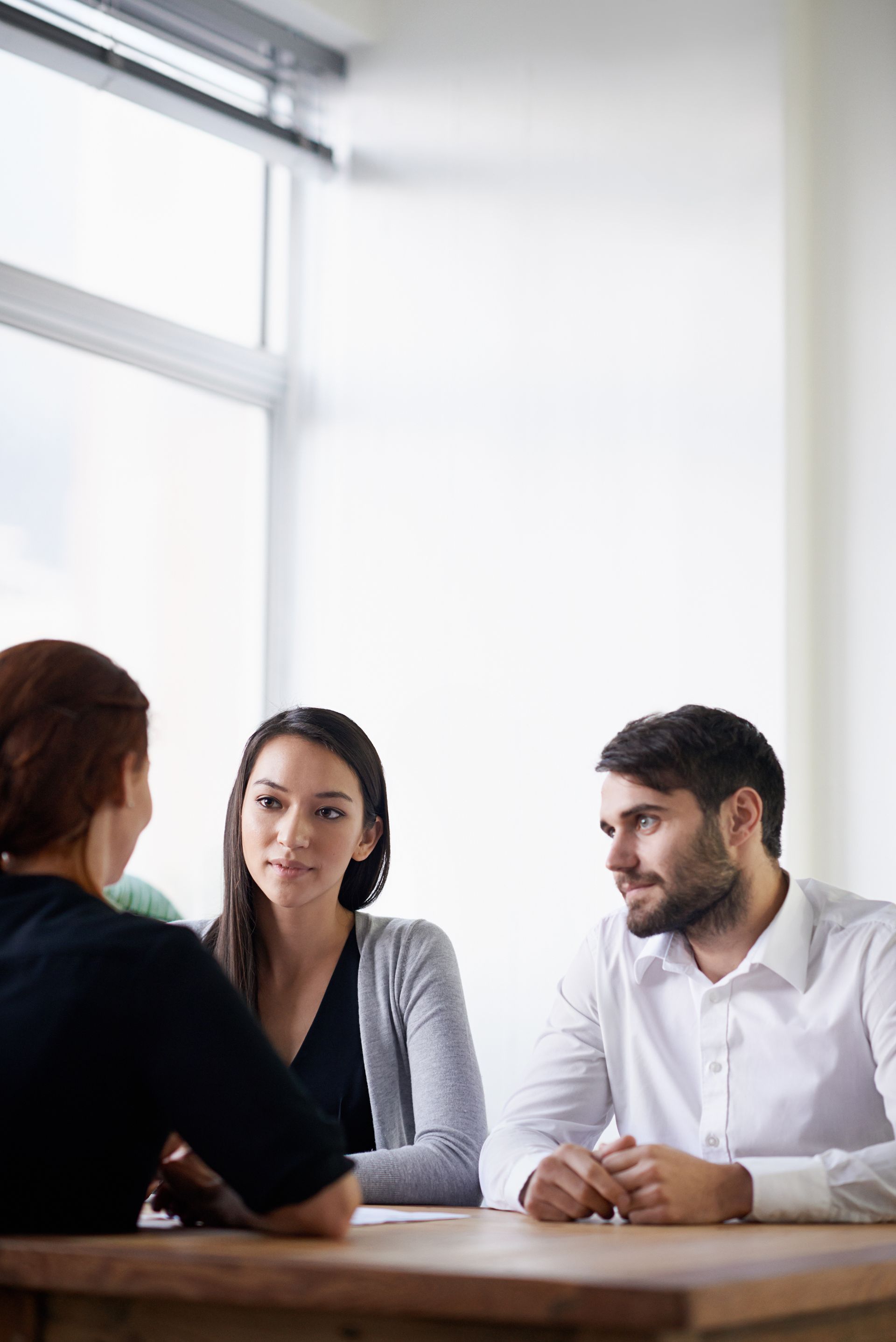 A man and a woman are sitting at a table having a conversation.