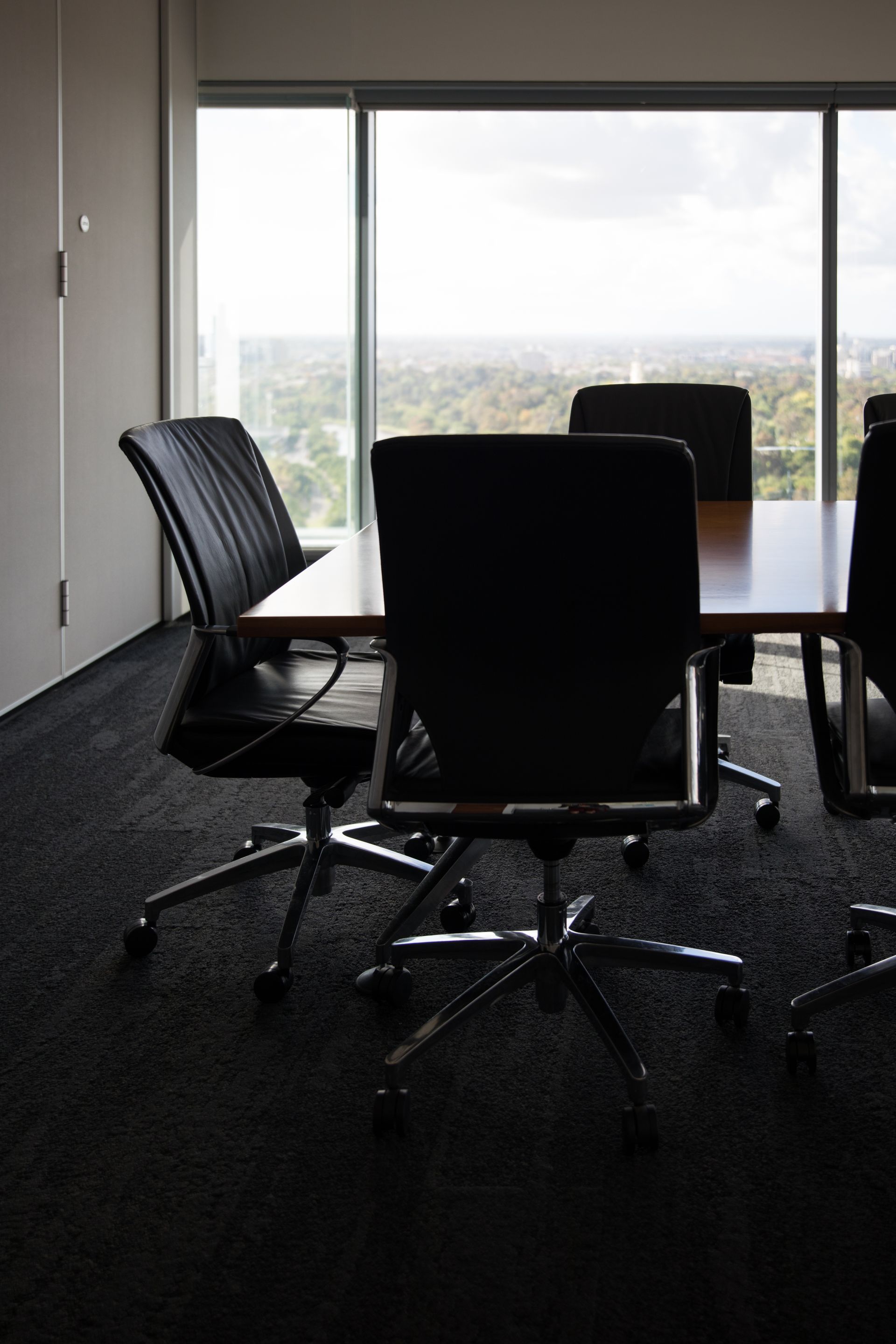 A conference room with a table and chairs and a large window