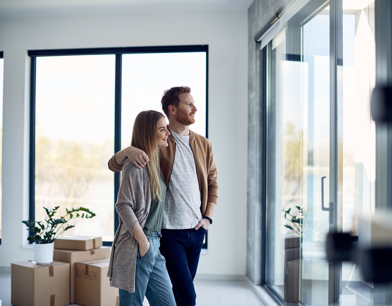 A man and a woman are standing in a room with cardboard boxes.