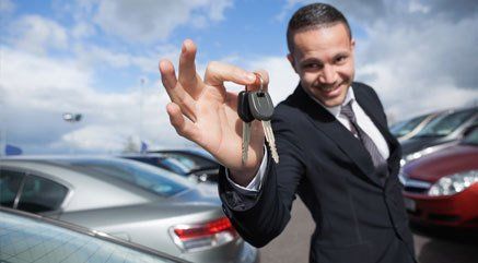 a man smiling holding the car keys