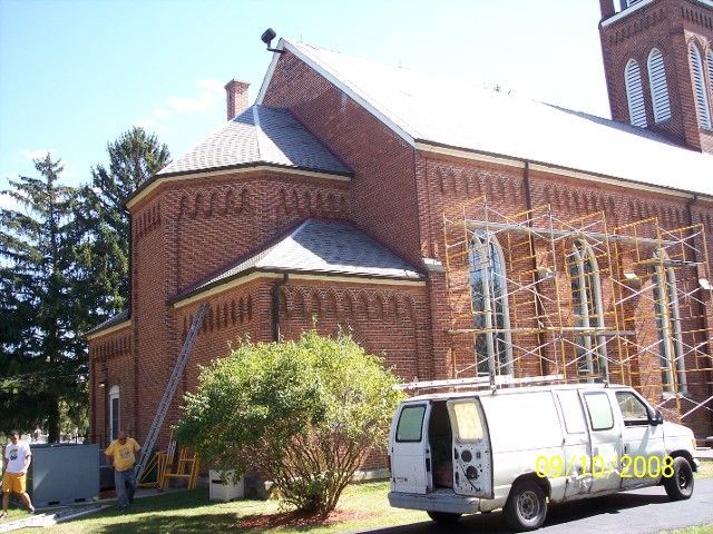 A White Van Is Parked in Front of A Brick Building | Detroit, MI | Yellow Rose Builders