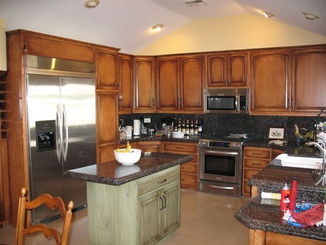 Modern kitchen with wood cabinets, stainless steel appliances, and a granite island counter