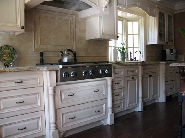 Elegant kitchen with cream cabinets, granite countertops, black stove, and sunlight by the window