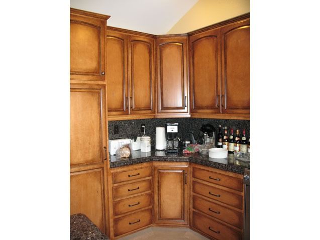 Corner kitchen with wooden cabinets, granite countertop, and small appliances on the counter