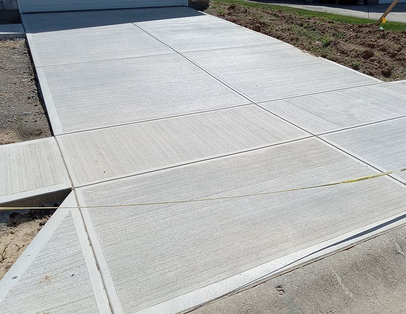Newly poured concrete driveway and sidewalk sections.