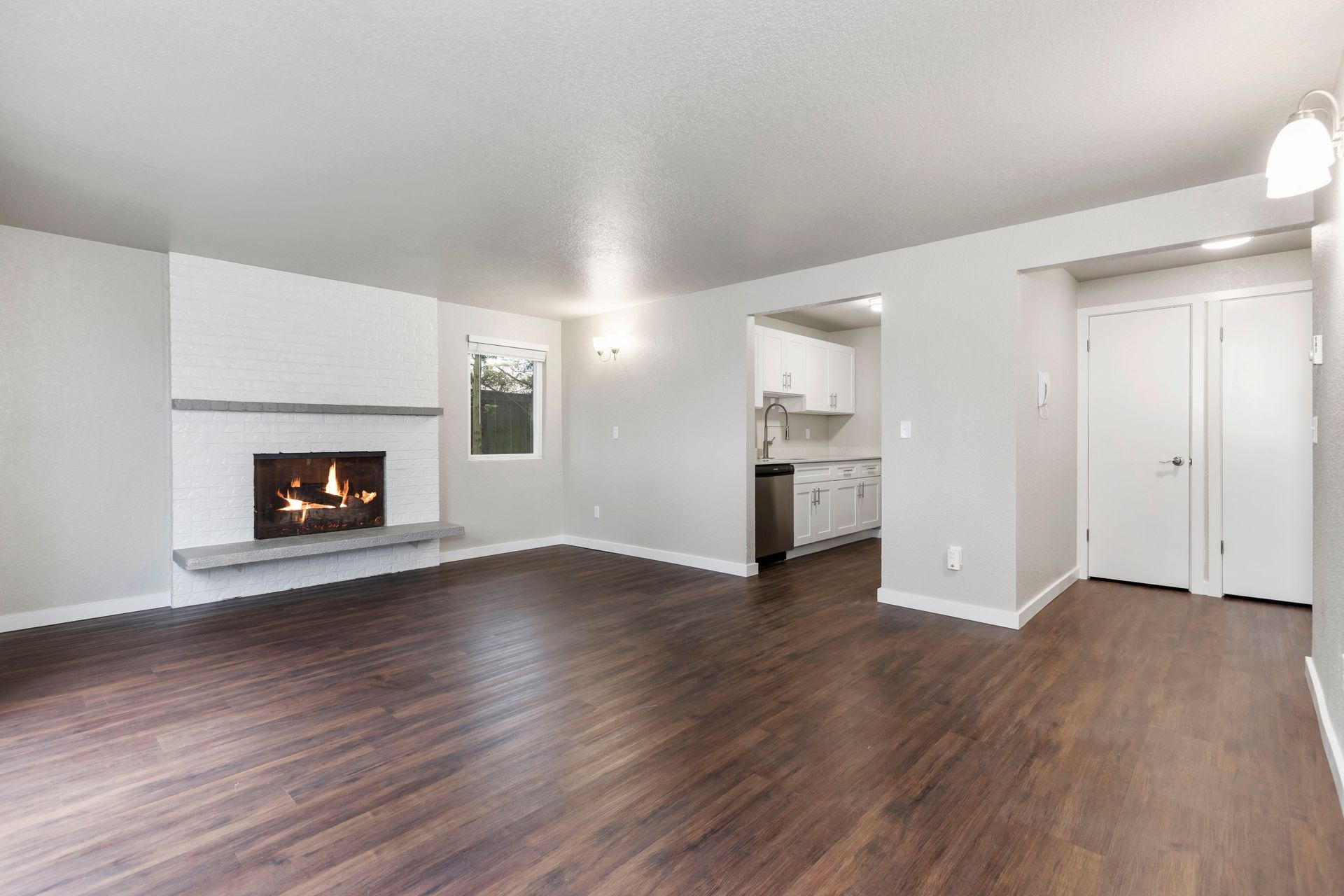 an empty living room with hardwood floors and a fireplace .