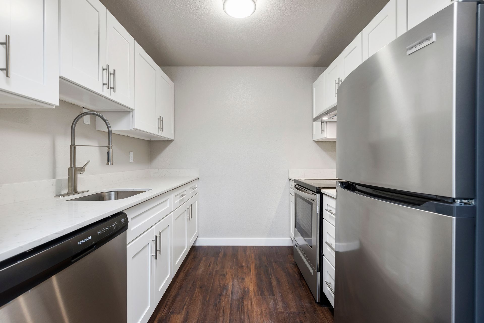 a kitchen with stainless steel appliances and white cabinets .