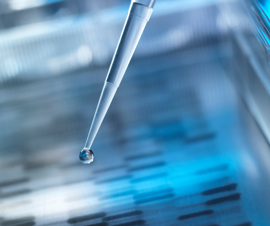 A pipette with a drop of liquid coming out of it