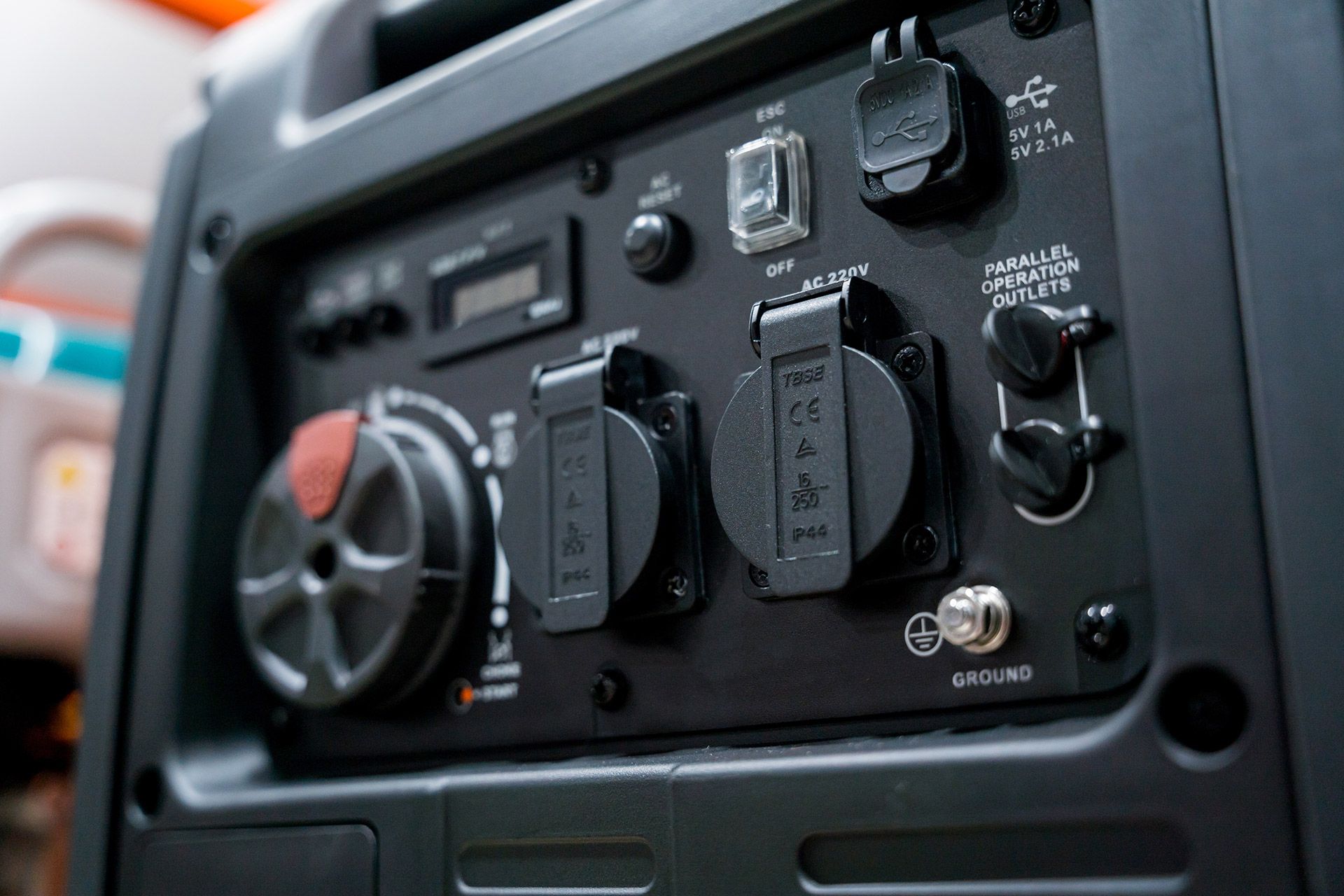 Control panel of a portable inverter generator featuring dual AC outlets, a USB port, and engine control dials.
