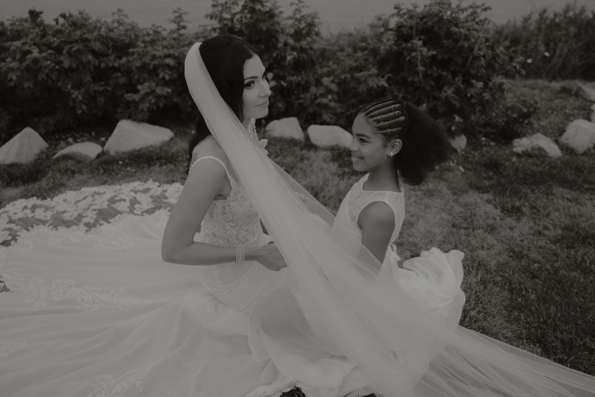 A black and white photo of a bride and her flower girl.