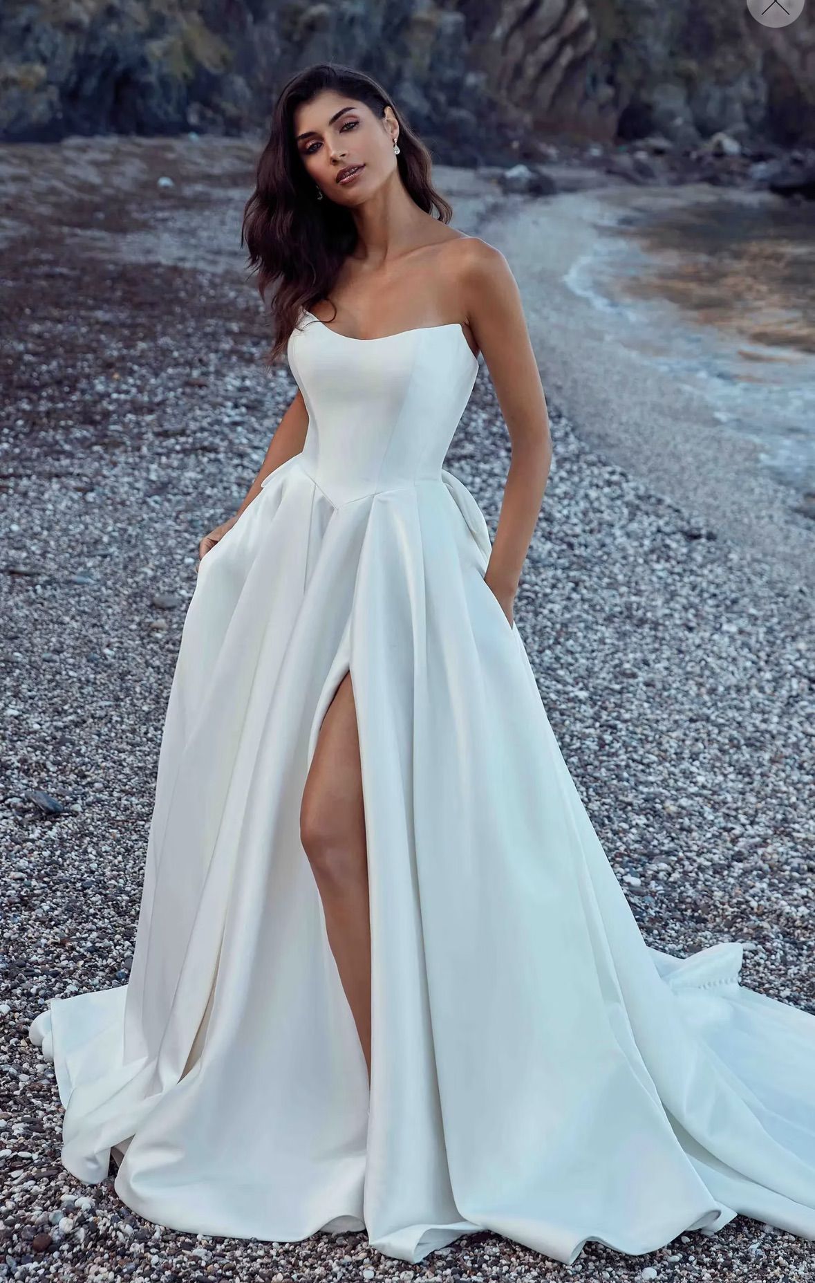 A woman in a wedding dress is standing in front of a building.