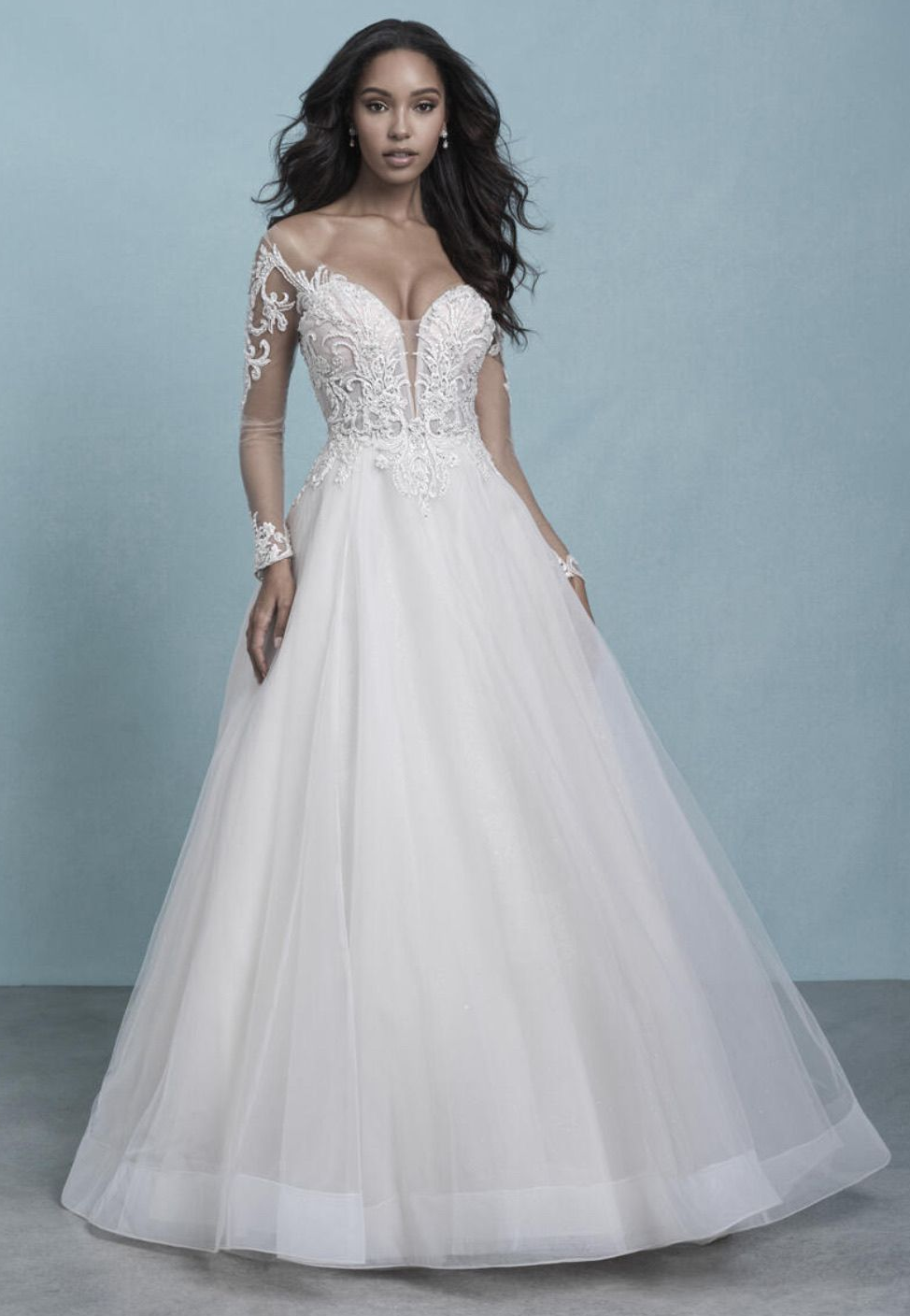 Woman in a white wedding gown with long sleeves, off-the-shoulder, and a full skirt.