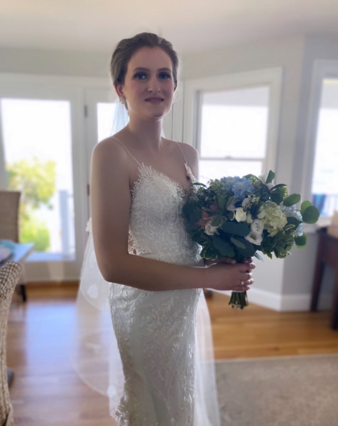 A woman in a wedding dress is holding a bouquet of flowers.