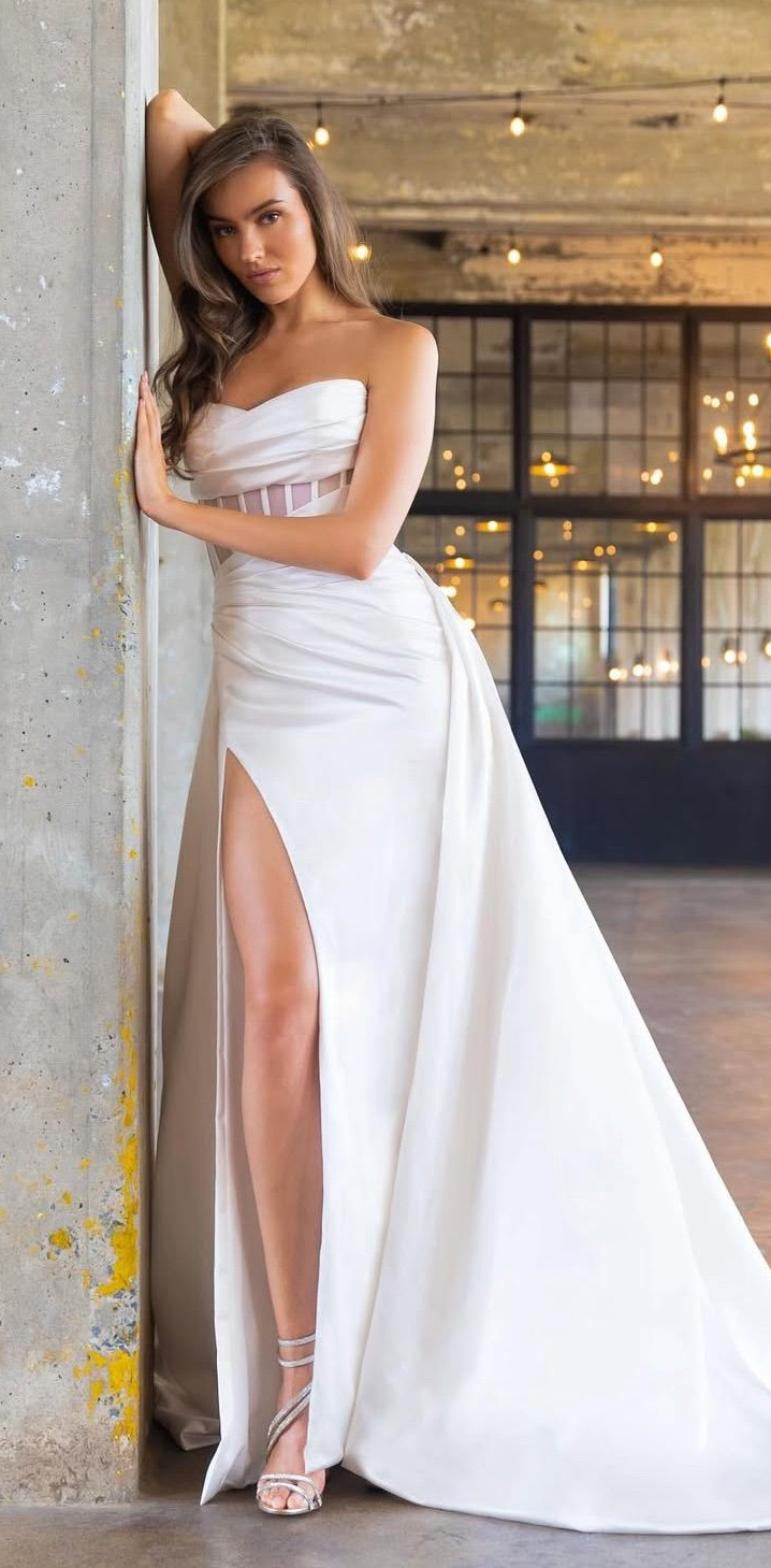 A woman is wearing a white lace wedding dress with short sleeves.