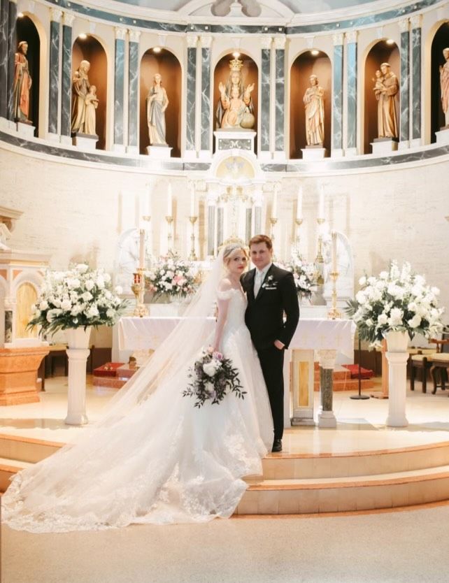 A bride and groom are posing for a picture in a church