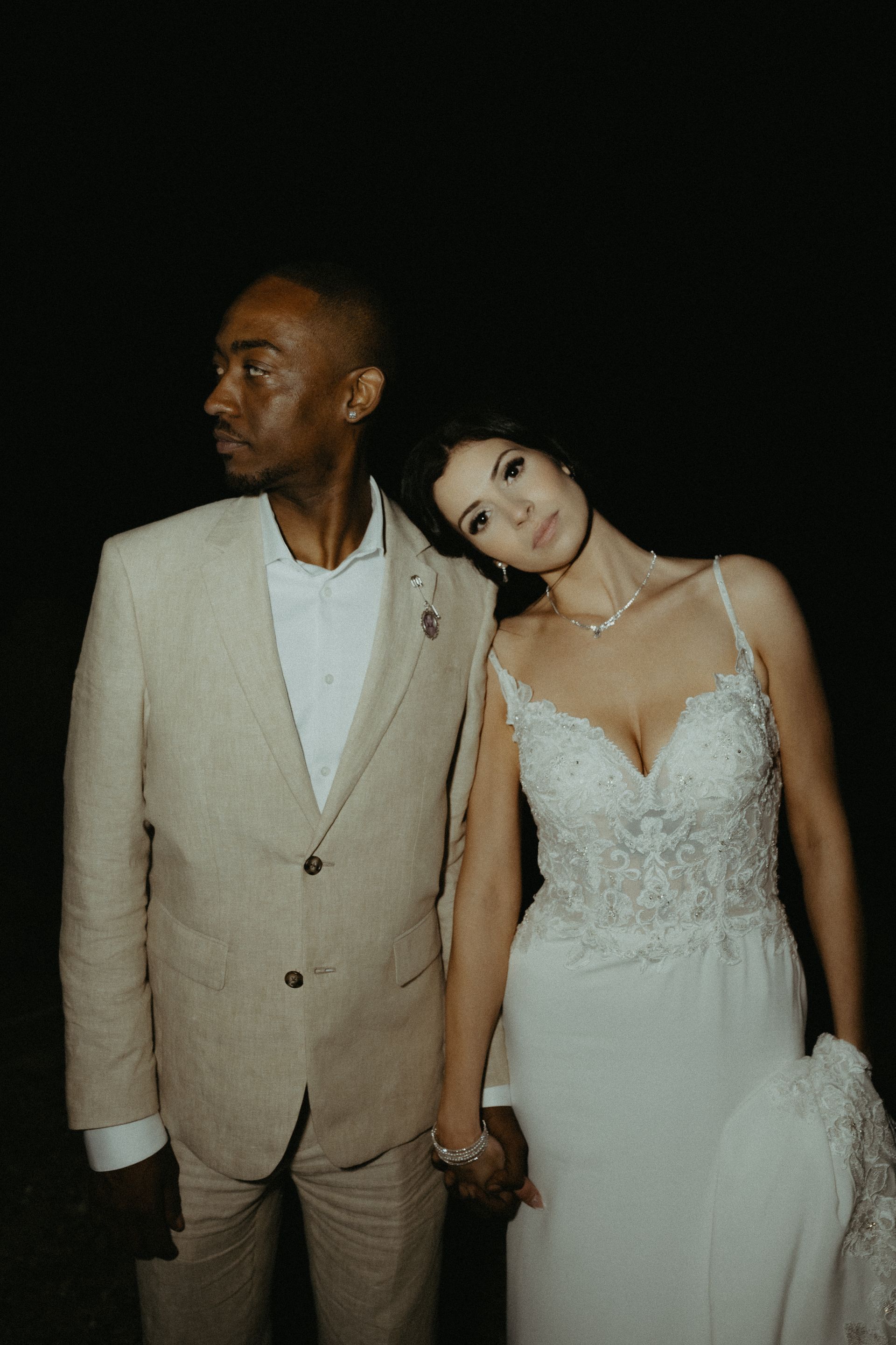 A bride and groom are holding hands and posing for a picture.