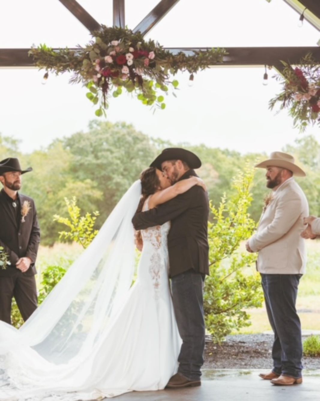 A bride and groom kiss during their wedding ceremony