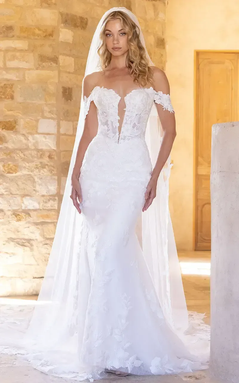 A woman in a white wedding dress is standing on a balcony.