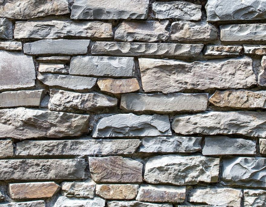 A close up of a stone wall made of different types of rocks.