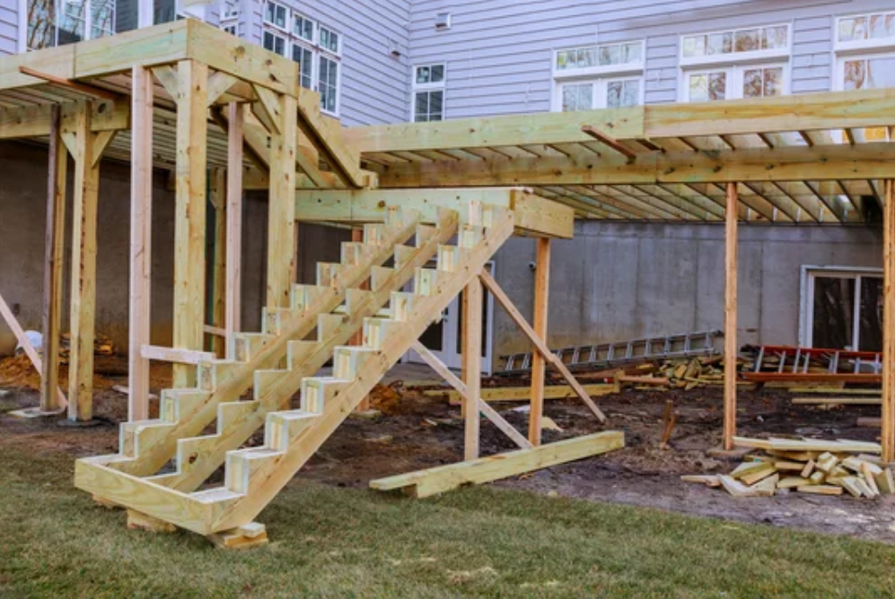 A wooden deck is being built with stairs.